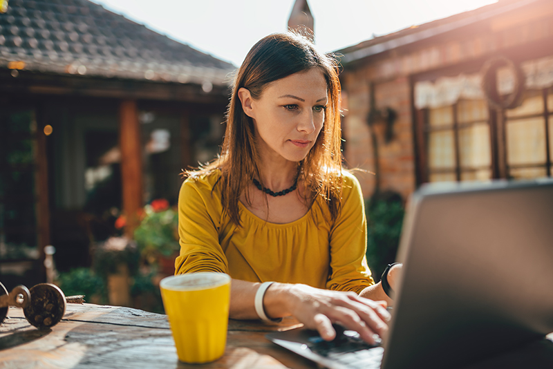 A woman working on a laptop; budgeting tips how much to spend on rent