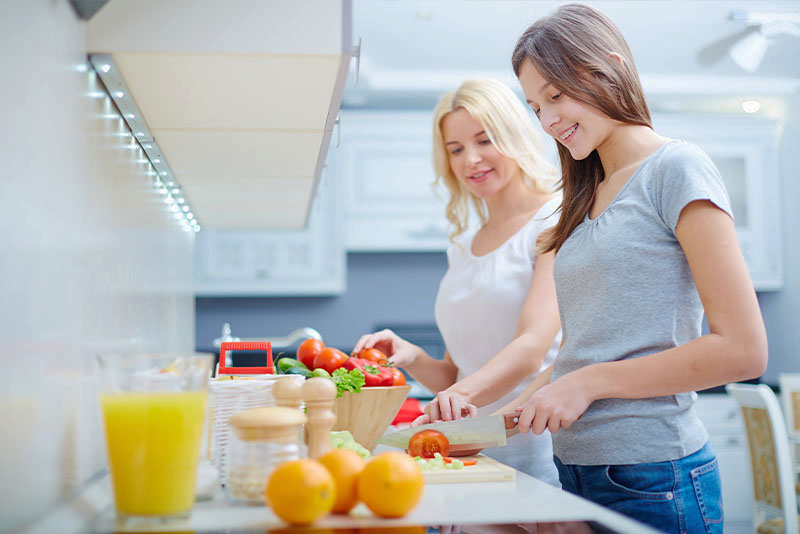 no spend month, two women making food