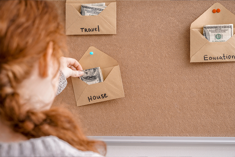 envelope budget system, girl putting money in envelope