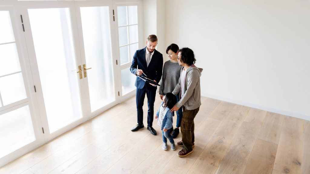 couple discussing purchasing a home with a realtor- one of the home buying tips discussed in this blog