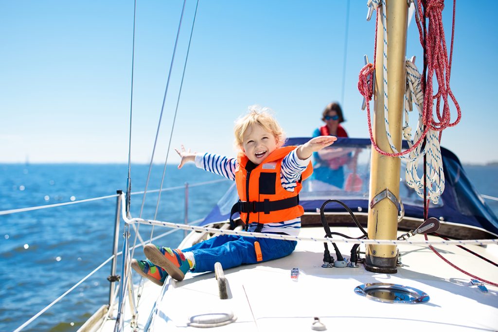 small boy smiling on a boat due to his family getting a credit union boat loans