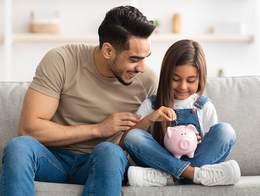 Father and daughter holding piggy bank