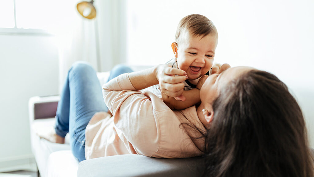 Mom holding and playing with baby for a blog about personal loans for single parents