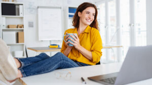 woman with feet kicked up in front of laptop for a blog about how to get your money right in 2025