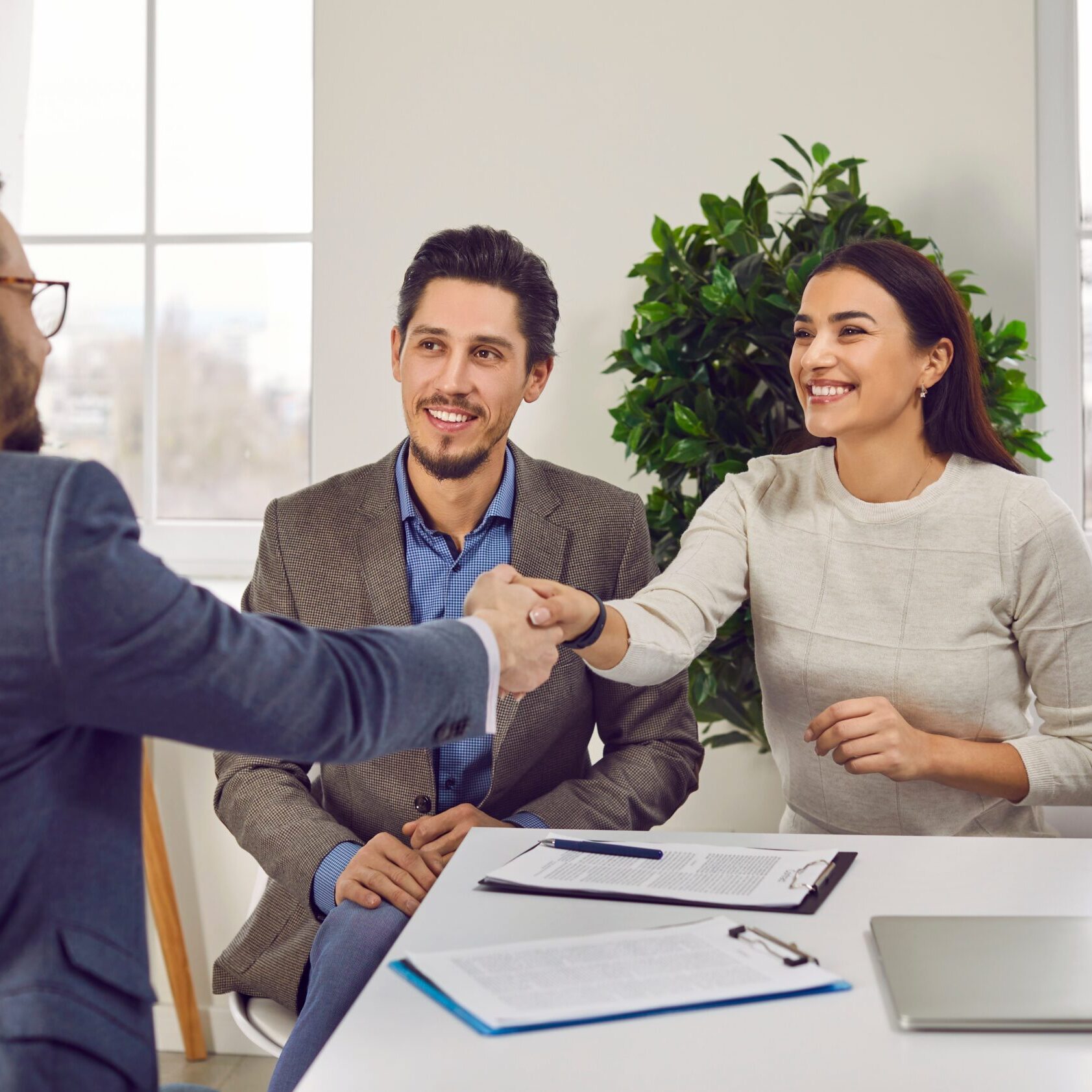 Portrait,Of,A,Happy,Couple,Shaking,Hands,With,A,Male